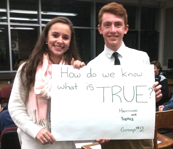 Harwood students Harrison and Sophia hold up one of the philosophical questions to help facilitate discussion at the Socrates Cafe. Photo: Tracy Brannstrom