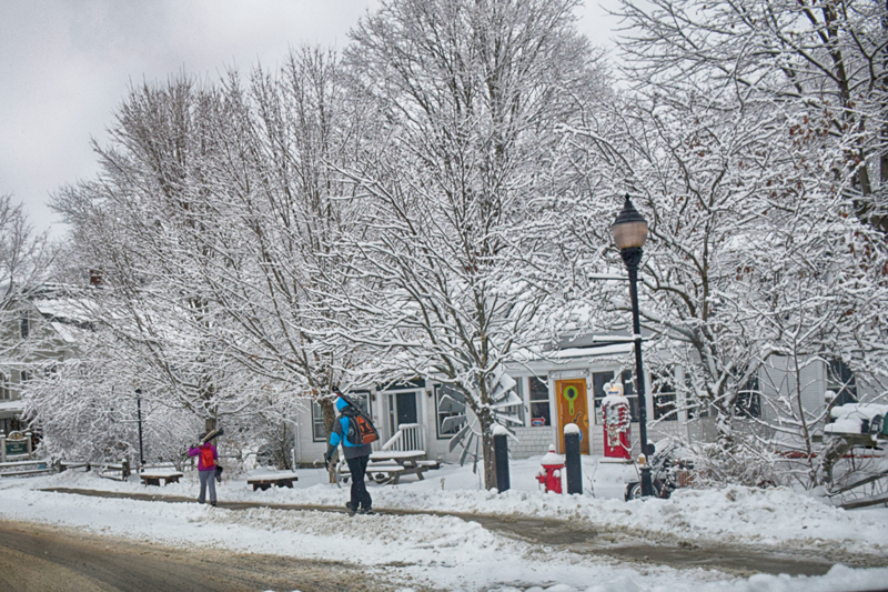 Skiers head to bus stop for a ride to the mountain. Photo: Jeff Knight
