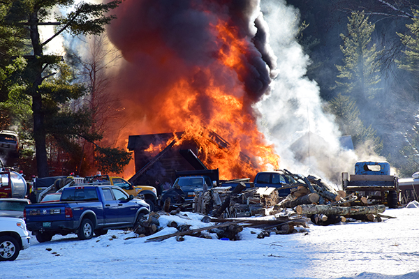 Flames billow from Tiger's Auto Repair as firefighters fight the blaze. Photo: Jeff Knight