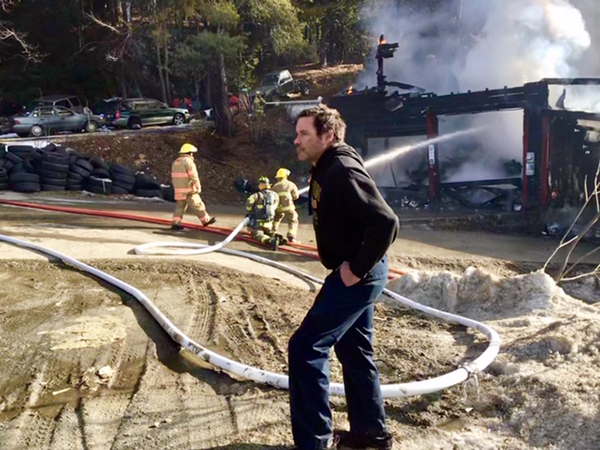Tiger Baird looks on as firefighters battle the flames that destroyed his garage. Firefighters were able to save his adjacent residence. Photo: Andy Yeager