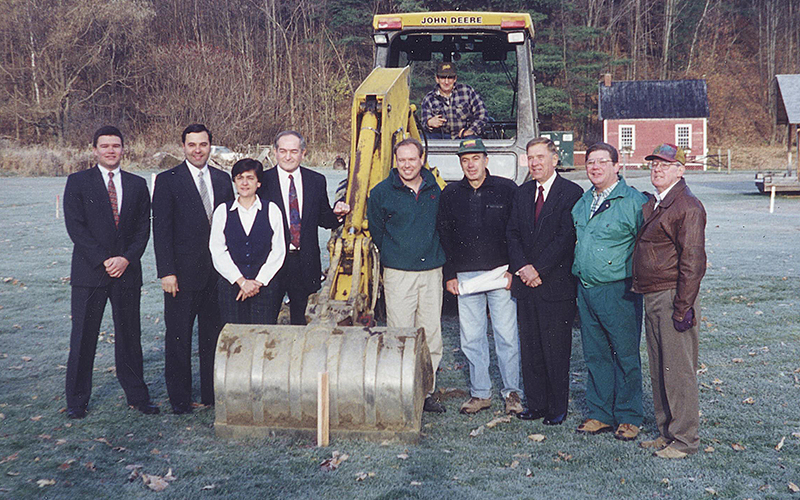 Brothers Building celebrates almost six decades of building homes and businesses in The Valley. In this photo Johnny Johnson, on the backhoe, is framed by bank executives from Northfield Savings Bank on the left. On the right, Ron Graves Jr., Dick Brothers, a bank executive, Pat Thompson and Ron Graves Sr. The photo was taken at the ground breaking for the new Northfield Savings Bank. Brothers Building file photo.