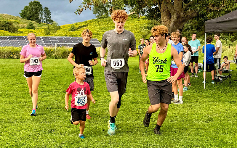 Jackson Migonis, age 5, of Waterbury leads Harwood runners (R to L) Indy Metcalf (green shirt), Atticus Ellis, Mateo Metcalf (black shirt) and Alex Isham on a victory lap at the final Harwood Fun on August 22 at Crossett Brook Middle School.