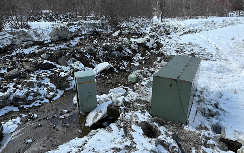 Water in the Crossett Brook flows into the utility box area along the middle school driveway on Thursday. Photo by Gordon Miller